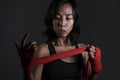 Portrait of sporty and fit fighter Asian Chinese woman using wrist wraps wrapping before mma fight sport or boxing workout looking