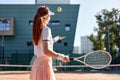 portrait of sporty lady tennis player with racket, raising throwing ball up
