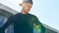 Portrait of a sporty young man in sportswear with hands on the waist posing on a sunlight. An athletic man taking a break after