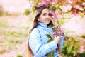 Portrait of a spring young girl, beautiful face, closeup on eyes at sakura tree in the garden. Royalty Free Stock Photo