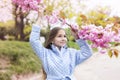 Portrait of a spring young girl, beautiful face, closeup on eyes at sakura tree in the garden. Royalty Free Stock Photo