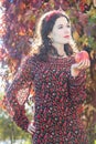 Portrait of standing autumn girl in fall head wreath with red apple in arm Royalty Free Stock Photo