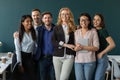 Portrait of standing in row smiling team embracing looking at camera. Royalty Free Stock Photo