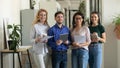 Portrait of standing smiling team with documents looking at camera. Royalty Free Stock Photo