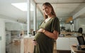 Portrait, stomach and a pregnant woman in her business office at the start of her maternity leave from work. Company