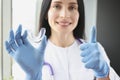 Stomatologist holding mouthguard for teeth and showing thumb up sign