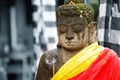 Portrait of stone buddha statue in yellow and red shawl Royalty Free Stock Photo