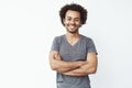 Portrait of stong and handsome african male student looking at camera smiling with crossed arms over white wall. Soon to