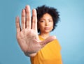 Portrait, stop hand sign and woman in studio isolated on a blue background mockup space. African person, face and ban