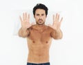 Portrait, stop and palms of a man on his bed in studio isolated on a white background for rejection. Face, hand gesture