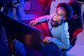 Portrait Streamer African young woman professional gamer playing online games computer, neon color