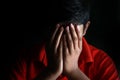 Portrait of a stressed Asian boy in front of black background. An Indian melancholy boy is thinking. Sadness expression of a boy. Royalty Free Stock Photo