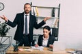 portrait of stressed businessman and focused colleague working at workplace with laptop Royalty Free Stock Photo