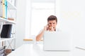 Portrait of a stressed businessman talking on phone in office Royalty Free Stock Photo