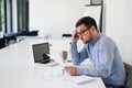 Portrait of stressed out and worried troublesome overworked businessman entrepreneur looking documents report in modern bright Royalty Free Stock Photo