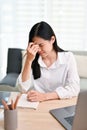 Stressed Asian businesswoman worried about her project`s deadline, suffering from headache Royalty Free Stock Photo