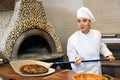 Stressed woman chef preparing pizza in pizzeria Royalty Free Stock Photo