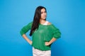 Portrait of strict young woman in green casual clothes looking camera, stand with arms akimbo on waist isolated on