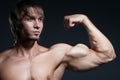 Portrait of strong healthy handsome Athletic Man Fitness Model posing near dark gray wall Royalty Free Stock Photo