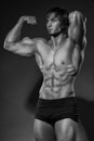 Portrait of strong healthy handsome Athletic Man Fitness Model posing near dark gray wall Royalty Free Stock Photo