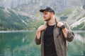 portrait of strong hiker man in front of lake in mountains