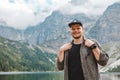 portrait of strong hiker man in front of lake in mountains