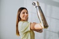 Portrait of a strong and independent woman with a bionic prosthetic arm shows a bicep on a light background Royalty Free Stock Photo