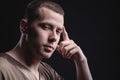 Portrait of a strong and large male masseur in special clothes with a finger at the temple reads your thoughts and knows Royalty Free Stock Photo