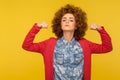 Portrait of strong proud woman with curly hair raising arms showing biceps as metaphor of female power Royalty Free Stock Photo