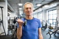 Strong senior man holding dumbbell in gym Royalty Free Stock Photo