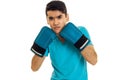 Portrait of strong sportsman with dark hair practicing boxing in blue gloves and uniform isolated on white background Royalty Free Stock Photo