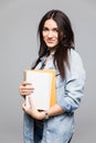 Portrait of young student holding a book over grey background Royalty Free Stock Photo