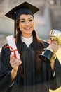 Shes achieved outstanding merit. Portrait of a student holding her diploma and trophy on graduation day. Royalty Free Stock Photo