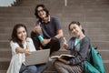 Portrait students sit down working in groups on the floor stairs campus Royalty Free Stock Photo