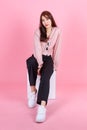 Portrait studio shot of Asian young beautiful hipster female teen model in casual street wears sneakers and sunglasses posing Royalty Free Stock Photo