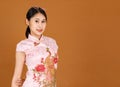 Portrait studio shot of millennial Asian female model in pink cheongsam qipao traditional festival peacock and flowers pattern Royalty Free Stock Photo