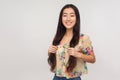 Portrait of stunning asian girl in summer blouse holding her beautiful long brunette hair and smiling at camera