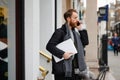 Portrait of a stylish bearded business man with a laptop in his hands talking on the smartphone Royalty Free Stock Photo