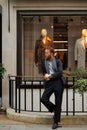 Portrait of a stylish bearded man against the background of elegant clothing store window. Royalty Free Stock Photo