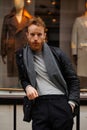 Portrait of a stylish bearded man against the background of elegant clothing store window. Royalty Free Stock Photo