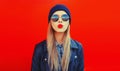 Portrait of stylish beautiful blonde woman blowing her red lips sending sweet air kiss wearing round sunglasses, black rock style Royalty Free Stock Photo