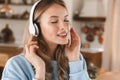 Portrait of stylish blond girl 20s wearing headphones listening to music at home Royalty Free Stock Photo