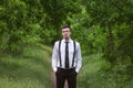 Portrait of stylish brunet young man, wearing white shirt, black tie, suspenders and glasses Royalty Free Stock Photo
