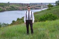 Portrait of stylish brunet young man, wearing white shirt, black tie, suspenders and sunglasses Royalty Free Stock Photo