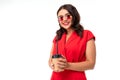 Portrait of stylish brunette girl in sunglasses and a red dress with a glass on a white background Royalty Free Stock Photo