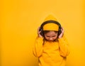 Portrait of stylish cute little kid girl in yellow fashion clothes isolated on yellow color background. Modern child in Royalty Free Stock Photo