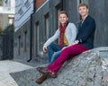 Portrait of stylish fashionable twin brothers sitting on the sta Royalty Free Stock Photo