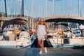 Portrait of a stylish girl near the sea in a yacht club. Girl on the pier near the yacht Parking lot