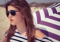 Portrait of a stylish girl in a striped t-shirt and sunglasses b Royalty Free Stock Photo