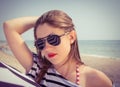 Portrait of a stylish girl in a striped t-shirt and sunglasses b Royalty Free Stock Photo